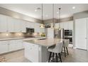 Modern kitchen featuring white cabinetry, a granite island, and stainless steel appliances at 11609 W Andrew Ln, Peoria, AZ 85383