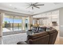 Open-concept living room with a view of the backyard pool and modern kitchen at 11609 W Andrew Ln, Peoria, AZ 85383