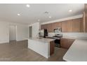 Bright kitchen featuring stainless steel appliances, a large island, and a view into the adjacent living space at 12366 W Marguerite Ave, Avondale, AZ 85323