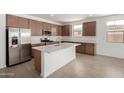 Modern kitchen with stainless steel appliances, white countertops, a large island, and wooden cabinetry at 12366 W Marguerite Ave, Avondale, AZ 85323