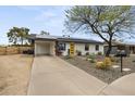 Single Gathering home featuring solar panels, a yellow door, a covered parking and desert landscaping at 13419 N 35Th St, Phoenix, AZ 85032