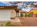 Inviting home entrance with a security door, manicured landscaping, and a two-car garage at 1414 W Grovers Ave, Phoenix, AZ 85023