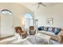 Sunlit living room featuring tile flooring, high ceilings, arched windows, and comfortable furnishings at 14300 W Bell Rd # 245, Surprise, AZ 85374