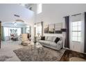Bright living room with high ceilings, neutral carpet, and large windows allowing ample natural light at 14733 N 159Th Dr, Surprise, AZ 85379
