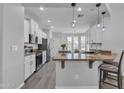 Bright, open kitchen with white cabinets, granite countertops, stainless steel appliances, and eat-in island at 1556 E Vesper Trl, Queen Creek, AZ 85140
