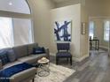 Comfortable gray sofa, stylish chair and chic decor in this well-lit living area at 16513 N 68Th Dr, Peoria, AZ 85382