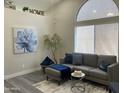 Cozy living room with a large window, gray sofa, and stylish decor at 16513 N 68Th Dr, Peoria, AZ 85382