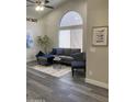 Inviting living area featuring a comfortable gray couch, large window, and modern decor at 16513 N 68Th Dr, Peoria, AZ 85382