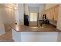 Another view of the kitchen showing the breakfast bar, appliances, and ample counter space at 17151 W Mohave St, Goodyear, AZ 85338