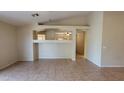 Open-concept living room with tiled floors, neutral paint, and an open view into adjacent rooms at 17151 W Mohave St, Goodyear, AZ 85338