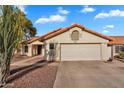 Well-maintained single-story house with a tile roof, two-car garage, and desert landscaping at 2218 E Desert Trumpet Rd, Phoenix, AZ 85048