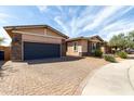 View of the exterior of a single-story home with a brick driveway and landscaping at 22434 S 226Th Pl, Queen Creek, AZ 85142