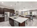 This kitchen flows into the dining and living area and features stainless appliances, a central island and pendant lighting at 22434 S 226Th Pl, Queen Creek, AZ 85142
