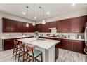 Spacious kitchen featuring an island, pendant lighting, and dark wood cabinets at 22434 S 226Th Pl, Queen Creek, AZ 85142