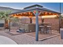 Outdoor gazebo featuring a hot tub, patio seating, pavers, and string lights at 24721 W Dove Butte --, Buckeye, AZ 85326