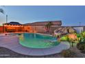 A resort-style pool with waterfall feature, colorful lights, desert landscaping, and a gazebo with hot tub at 24721 W Dove Butte --, Buckeye, AZ 85326