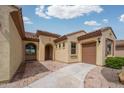 Beautiful home exterior showing a tiled roof, arched entry and a paved driveway and walkway at 26190 W Siesta Ln, Buckeye, AZ 85396