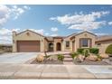 Charming, earth-toned home featuring a tile roof, arched entryway, and desert-friendly landscaping at 26190 W Siesta Ln, Buckeye, AZ 85396