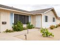 Close-up of the home's front entrance featuring a security door, desert landscaping, and charming light-blue shutters at 2710 E Cinnabar Ave, Phoenix, AZ 85028
