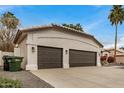 Three car garage featuring textured walls and brown garage doors at 2732 E Hillery Dr, Phoenix, AZ 85032