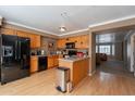 Well-equipped kitchen features wood cabinets, black appliances, and a serving bar, seamlessly flowing into the living area at 2875 W Highland St # 1152, Chandler, AZ 85224