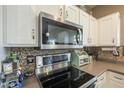 Close up of white cabinets and tiled backsplash in kitchen with stainless steel appliances at 3795 W Mercury Way, Chandler, AZ 85226