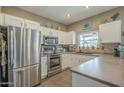 Bright kitchen features white cabinets, stainless steel appliances, and tile backsplash at 3795 W Mercury Way, Chandler, AZ 85226