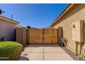 Wooden gate along the side of house provides backyard access, next to low brick wall at 40707 W Pryor Ln, Maricopa, AZ 85138