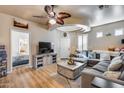 Inviting living room featuring a large sectional, wood floors, and modern ceiling fan at 4539 W Beautiful Ln, Laveen, AZ 85339