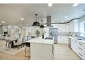 Bright, open kitchen with white cabinets, stainless steel appliances, island with bar seating, and pendant lighting at 4602 N 74Th Pl, Scottsdale, AZ 85251