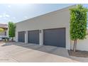 Attached four-car garage with dark gray doors and manicured landscaping around perimeter at 4617 E Elmwood Cir, Mesa, AZ 85205