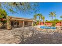 Expansive backyard featuring a pool, covered patio, paver stones, and lush tropical landscaping at 4901 S Vista Pl, Chandler, AZ 85248