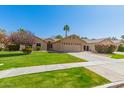 Beautiful home with mature trees, manicured lawn, and a spacious driveway leading to a two-car garage at 4901 S Vista Pl, Chandler, AZ 85248