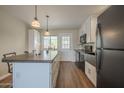 Well-lit kitchen featuring stainless steel appliances, an island, and wood laminate flooring at 5317 E Baltimore St, Mesa, AZ 85205