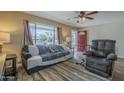 Cozy living room with a large window, comfortable seating, and a ceiling fan at 5317 E Baltimore St, Mesa, AZ 85205