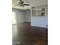 Spacious living room featuring wood-look tile flooring, ceiling fans, and view of the kitchen at 600 S Dobson Rd # 53, Mesa, AZ 85202