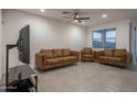 Bright living room featuring neutral-toned walls, tile flooring, and an elegant ceiling fan at 6732 W Pedro Ln, Laveen, AZ 85339