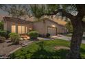 Charming single-story home with a well-maintained lawn, mature trees, and a two-car garage at 8405 W Utopia Rd, Peoria, AZ 85382