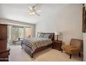 Bright main bedroom featuring a ceiling fan, neutral carpet, and a cozy window nook at 8405 W Utopia Rd, Peoria, AZ 85382