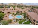 Aerial view of a community pool and manicured lawns, surrounded by well-kept homes and desert mountain views at 10655 N 9Th St # 115, Phoenix, AZ 85020