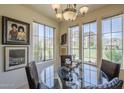 Dining room with chandelier, glass-top table, and views of the outdoors from large windows at 10655 N 9Th St # 115, Phoenix, AZ 85020