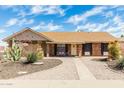 Charming brick home featuring manicured landscaping, a cozy front porch, and a welcoming entrance at 1240 E Indigo St, Mesa, AZ 85203