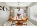 Cozy dining area features an oak table with 4 chairs and a window providing natural light at 15136 N 162Nd Ln, Surprise, AZ 85379