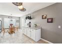 Cozy dining area with a view of the kitchen, white cabinets, and a hanging pot rack at 15136 N 162Nd Ln, Surprise, AZ 85379