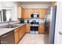 Well-lit kitchen featuring stainless steel appliances and light wood cabinetry at 2873 S Arroyo Ln, Gilbert, AZ 85295