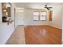 Bright living room featuring wood floors, a ceiling fan, and natural light from two windows at 2873 S Arroyo Ln, Gilbert, AZ 85295