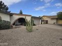 Single-story home showcasing xeriscaping, arched porch and a convenient two-car garage at 4718 W El Caminito Dr, Glendale, AZ 85302