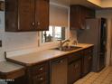 Kitchen featuring dark cabinetry, stainless steel appliances, and ample counter space at 4718 W El Caminito Dr, Glendale, AZ 85302