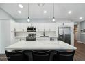 Modern kitchen with white cabinets, stainless steel appliances, and a large center island with seating at 10010 N 64Th Ave, Glendale, AZ 85302