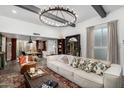 Bright and airy living room with a large sofa, chandelier and an adjacent dining area at 1025 E Northern Ave, Phoenix, AZ 85020